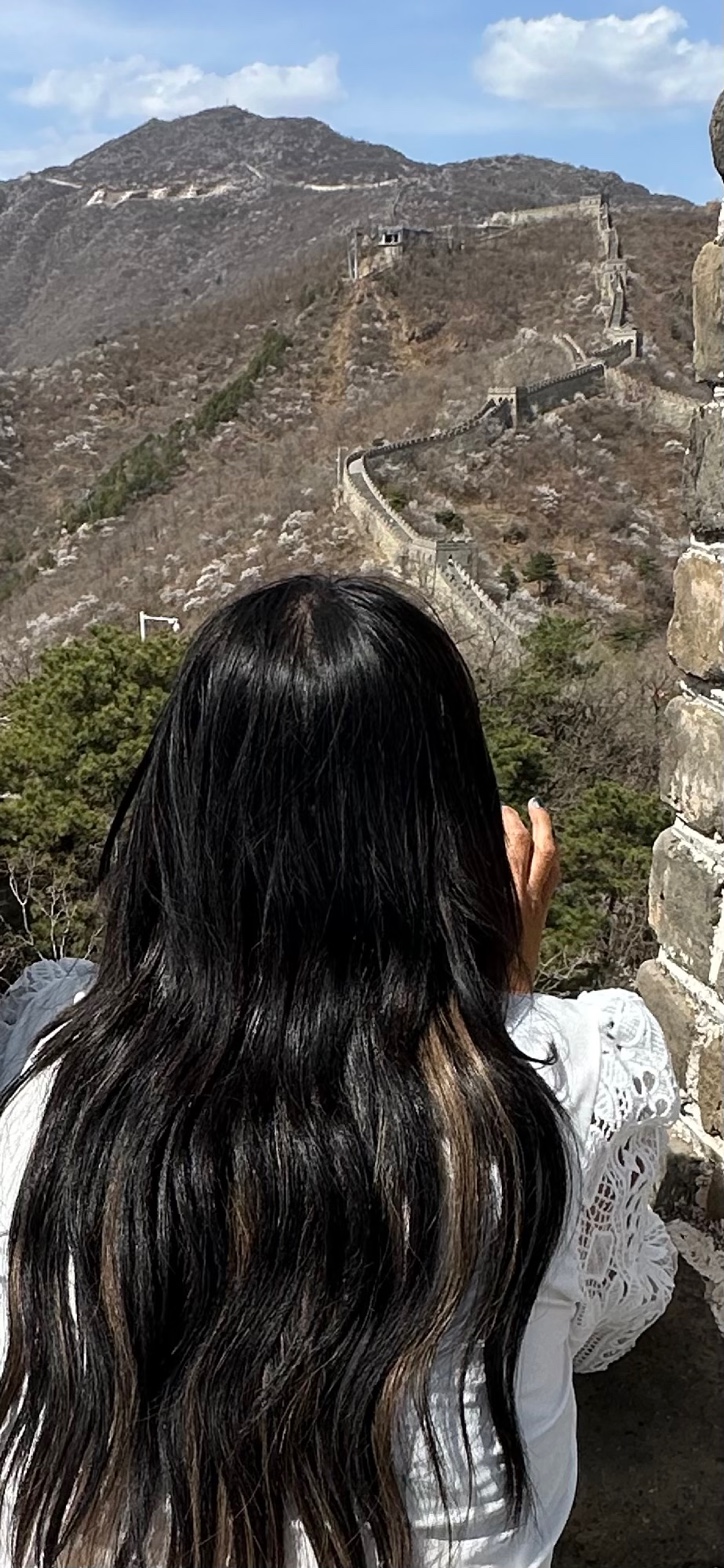 Cyndi looking out over the Great Wall stretching into the mountains