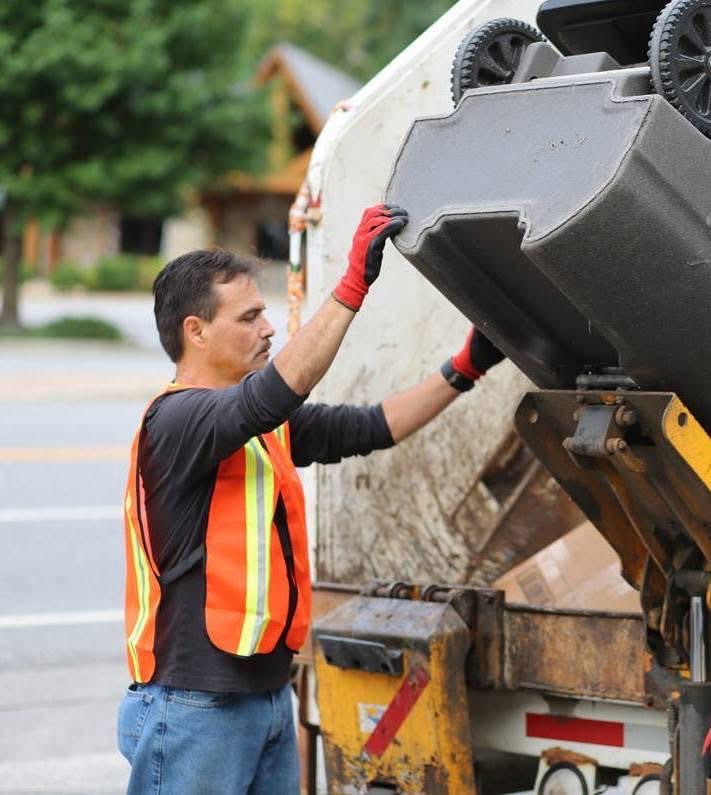 Chief Lambert emptying bins with the tribal sanitation crew