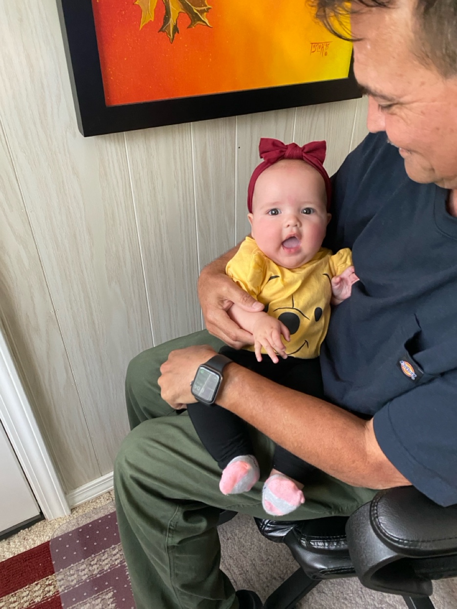 PopPop holding baby Lilou in a red bow